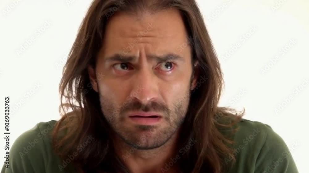 Man with long hair displays a range of confused and skeptical expressions against a clean white background Man with long hair displays a range of confused and skeptical expressions against a clean white background