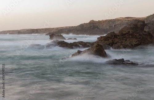 Obraz na płótnie Time-lapse photo of ocean waves crashing on the shore, showing the fluid motion