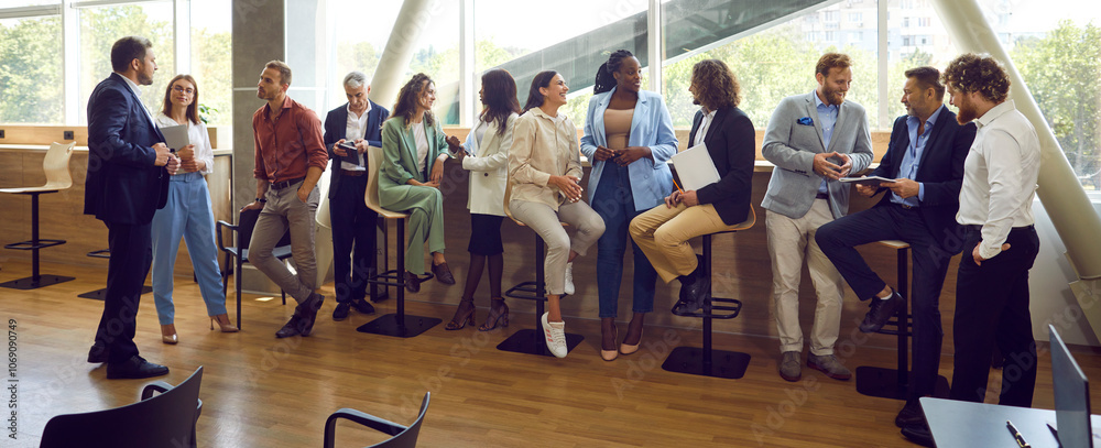 Obraz premium Diverse multinational business people men and women chatting after a meeting. Company employees or group of staff talking with each other in the office during the break in meeting room. Banner.