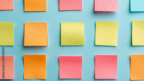 A vibrant arrangement of colorful sticky notes arranged neatly on a light blue background, evoking creativity and organization.