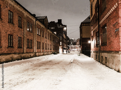 Picture of brick architecture Goteborg downtown at night in winter, snow lying on the street