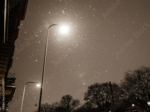 snow falling in light of street lamp