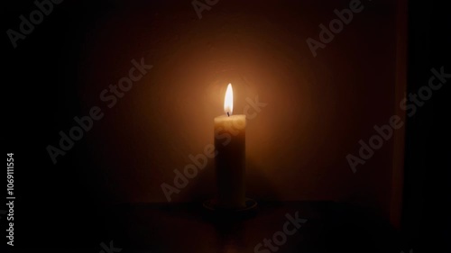 A serene candle flickers softly in the dark, creating a warm glow and tranquil atmosphere, evoking peace and contemplation.