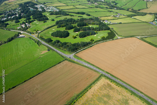 Obraz na płótnie Elevated view of road going through countryside with golf course in background w salonie