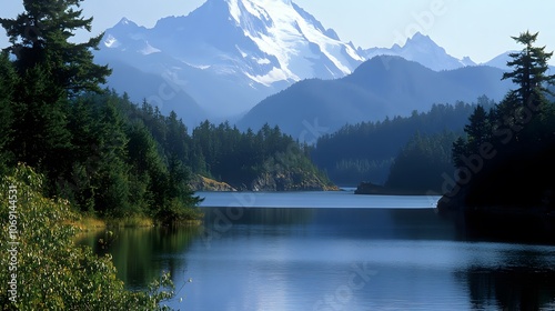 A serene mountain lake is framed by towering pine trees, with majestic snow-capped peaks rising in the background. The raw and tranquil scene captures the essence of untouched natural beauty. photo