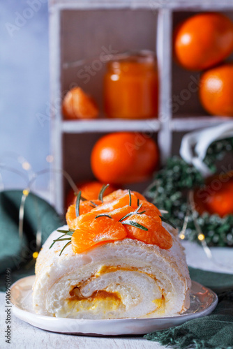 Obraz na płótnie Meringue roll filled with mascarpone, cream and tangerine jam on a background of tangerines and a green heart. w salonie