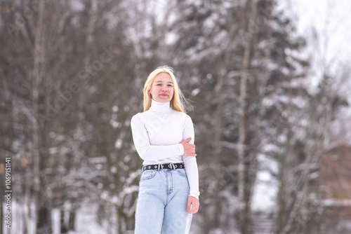 Portrait of young beautiful blonde girl outdoors in winter.