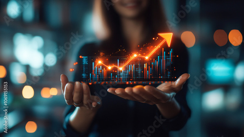 Businesswoman smiling and holding a glowing growth chart hologram with a rising arrow, symbolizing business success