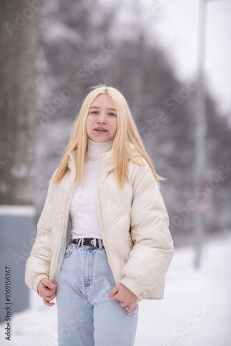 Portrait of young beautiful blonde girl outdoors in winter.