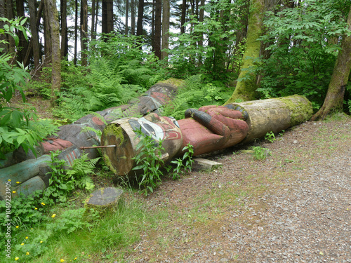 Fallen totem pole laying on the forest floor photo