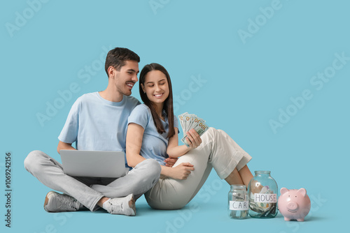 Young couple with money usi...