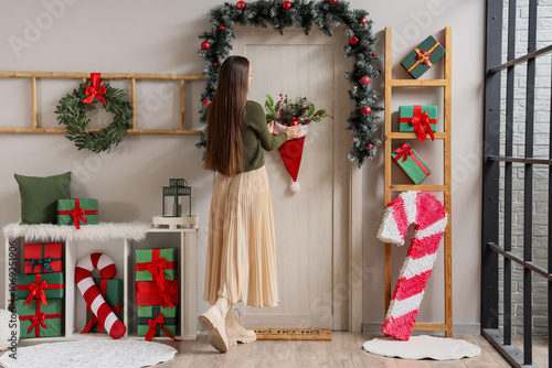 Young woman decorating door...