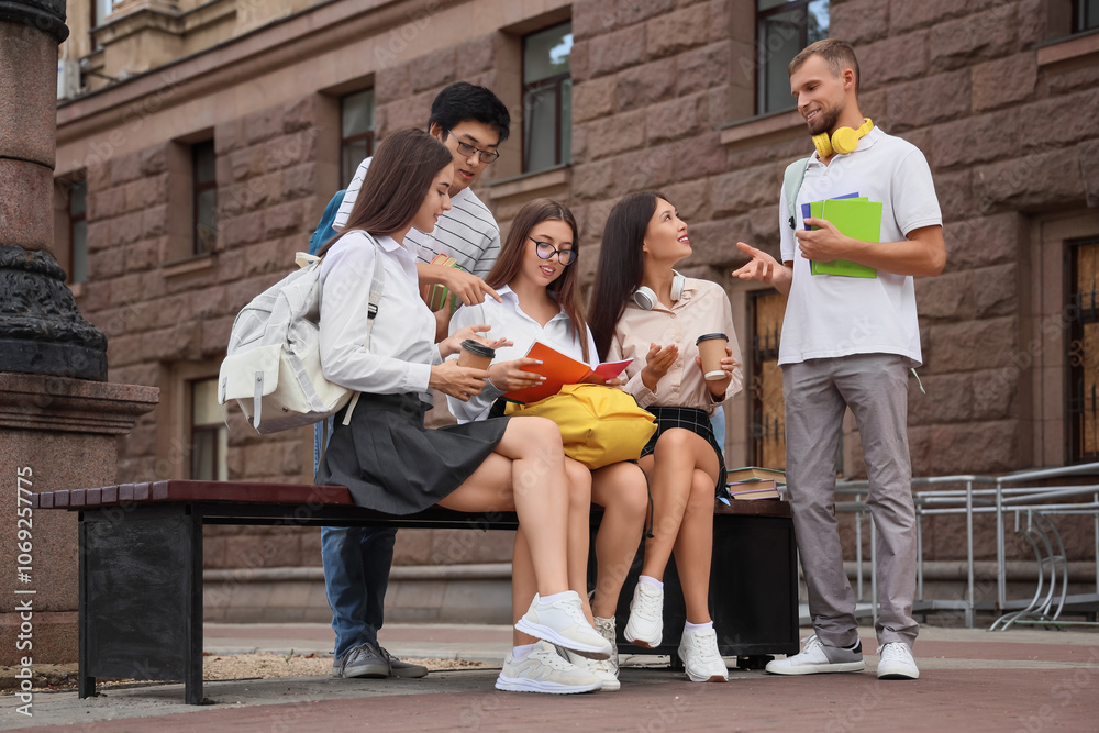Fototapeta premium Group of students with backpacks and copybooks near university