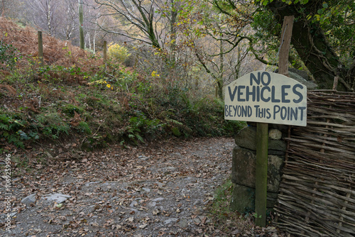 Sign next to a rough track with 'no vehicles beyond this point.' photo