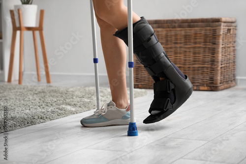 Принти на полотні Young woman with broken leg and crutches walking at home, closeup