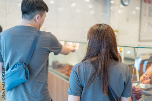 Photography Chinese Malaysian couple in their 30s shopping and chatting at a dried meat shop in Kuala Lumpur, Malaysia