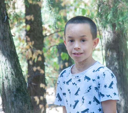 Portrait of caucasian little boy in the forest. About 7 years old.