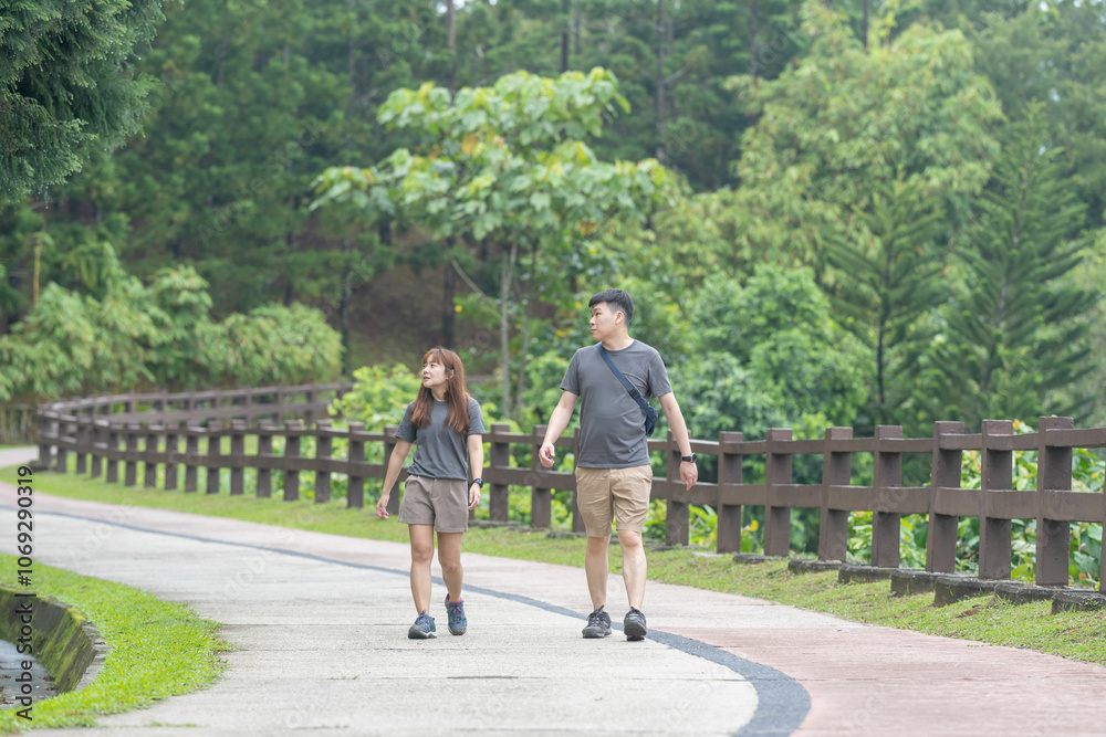 A Chinese-Malaysian couple in their 30s walk together in a green park with abundant water in Kuala Lumpur, Malaysia, on a sunny day in June 2024. A Chinese-Malaysian couple in their 30s walk together in a green park with abundant water in Kuala Lumpur, Malaysia, on a sunny day in June 2024.