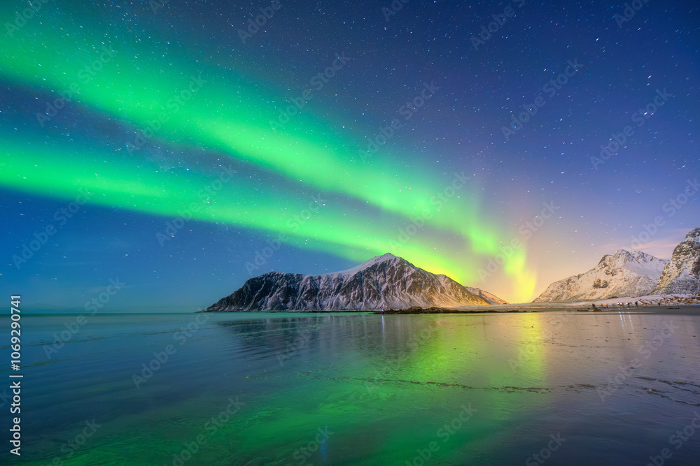 Aurora Borealis in Scandinavia. Norway, Lofoten islands. Northern lights over the mountains. Starry sky. Winter landscape on the north. Photo for background, wallpaper, postcards.