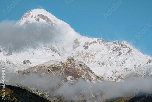 View on the snow covered Mount Kazbek from the village of Stepantsminda photo