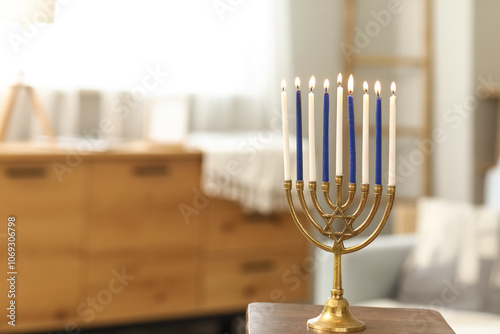 Menorah with burning candles on table at home, closeup. Hanukkah celebration photo