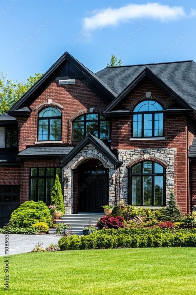 A large brick house with numerous windows, ideal for use in architectural or real estate photography A large brick house with numerous windows, ideal for use in architectural or real estate photography