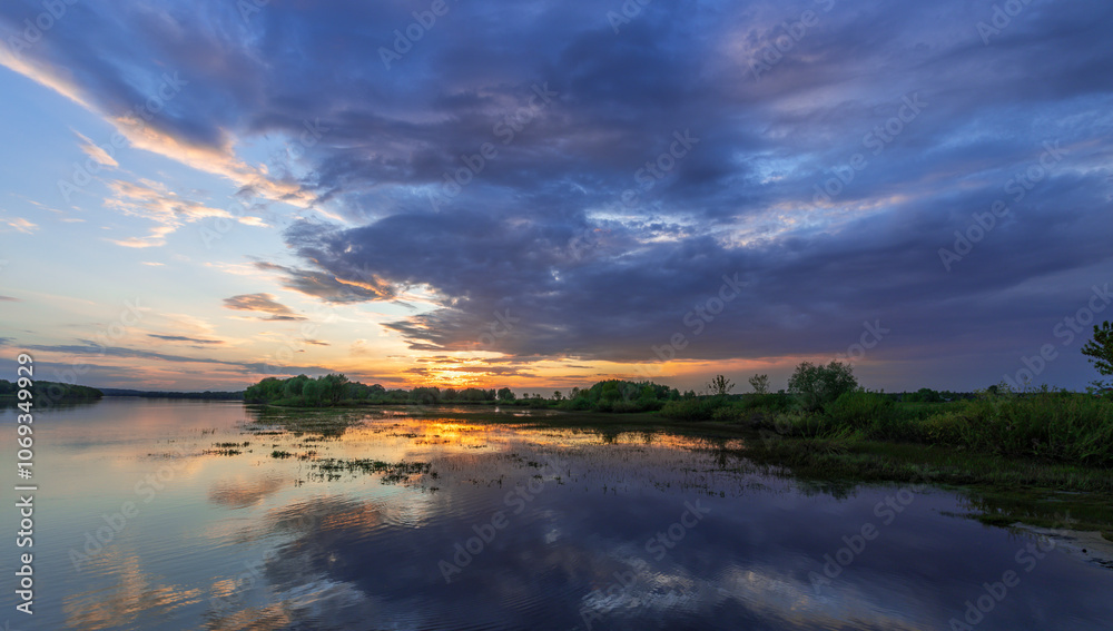 Beautiful sunset over a lake with a cloudy sky Beautiful sunset over a lake with a cloudy sky