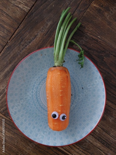 Carrot with googly eyes on plate
