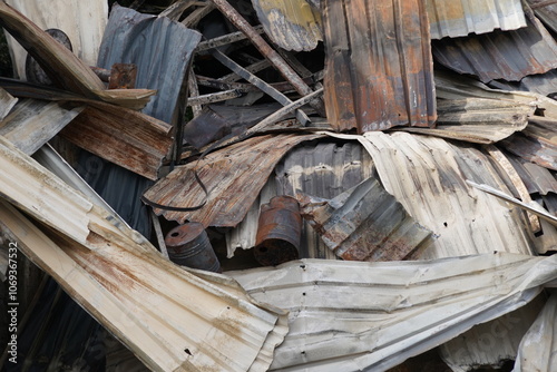 Close up view on corrugated aluminium  sheets damaged by fire. The metal is distorted with traced of smoke and can only be used as scrap. The capture is suitable as background. 
