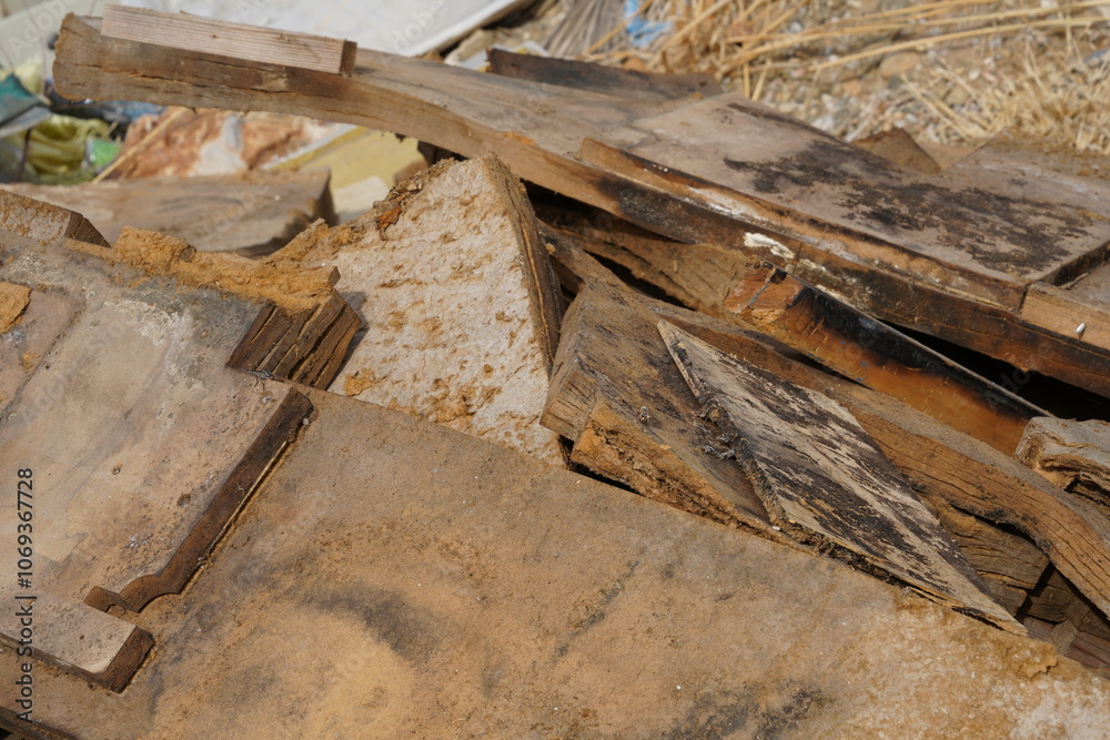 View of dismantled furniture and broken wooden planks, scattered in a heap of wooden rubble. The fragments, of various sizes, are dispersed across the scene. View of dismantled furniture and broken wooden planks, scattered in a heap of wooden rubble. The fragments, of various sizes, are dispersed across the scene.