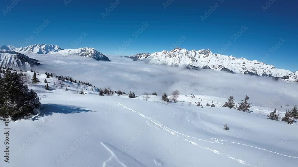 First person bird view drone clip flying in the French Alps during a sunny day on winter vacations near Vaujany, France. First person bird view drone clip flying in the French Alps during a sunny day on winter vacations near Vaujany, France.