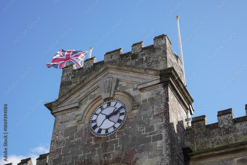 Obraz premium clock tower of stone building in UK town. Old English architecture.
