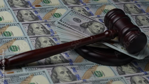 Wooden judge gavel, soundboard with US 100 dollar bills on the background, close up, rotates. Finance and justice concept