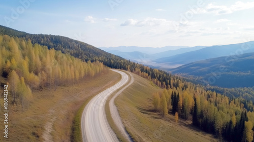 Serene autumn aerial view of curved mountain road through scenic forests and hills