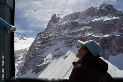 Woman gazing at snowy mountain landscape from cable car