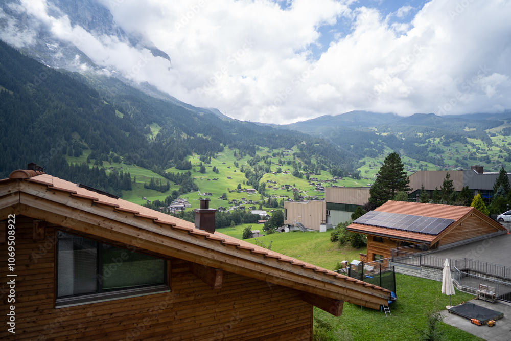 Scenic view of Grindelwald village with mist-covered mountains Scenic view of Grindelwald village with mist-covered mountains
