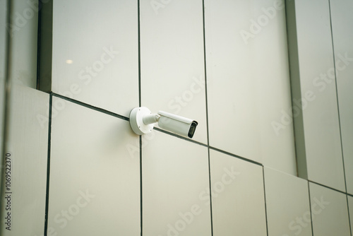 A sleek, modern surveillance camera has been installed on the exterior facade of a contemporary building design