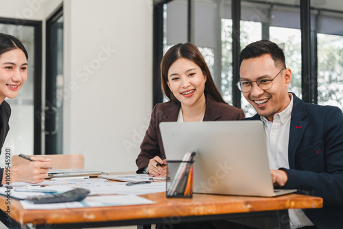 Efficient teamwork in modern office setting with three professionals collaborating on project. They are engaged and focused, showcasing positive work environment