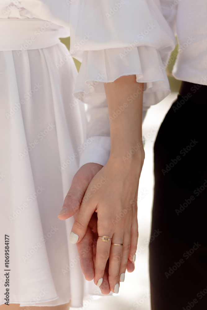 A couple in love touches each other with their hands. Love story of a young couple in love. Wedding rings on ring fingers. Concept of a marriage proposal. Starting a family. A couple in love touches each other with their hands. Love story of a young couple in love. Wedding rings on ring fingers. Concept of a marriage proposal. Starting a family.
