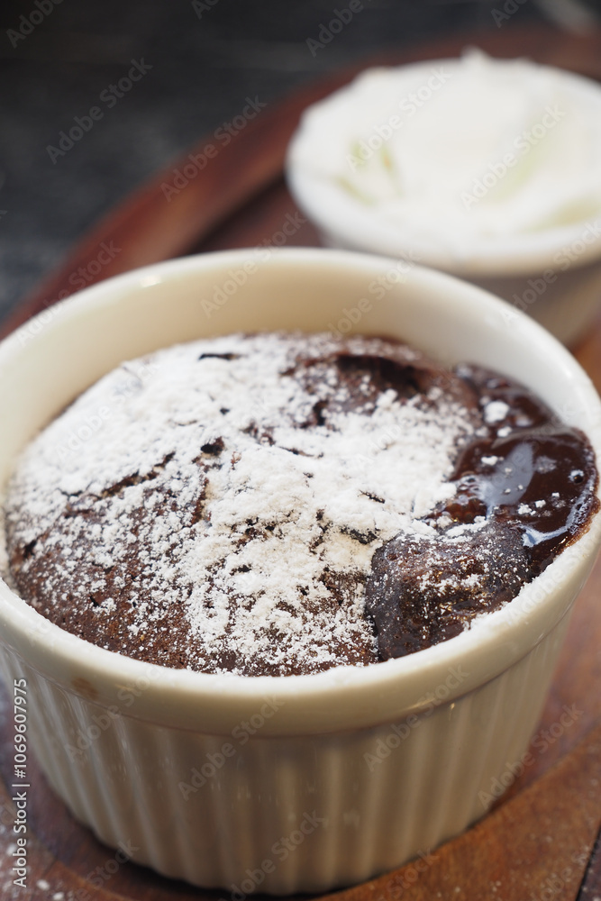 Delicious Chocolate Lava Cake with Powdered Sugar and Whipped Cream on Wooden Plate Delicious Chocolate Lava Cake with Powdered Sugar and Whipped Cream on Wooden Plate