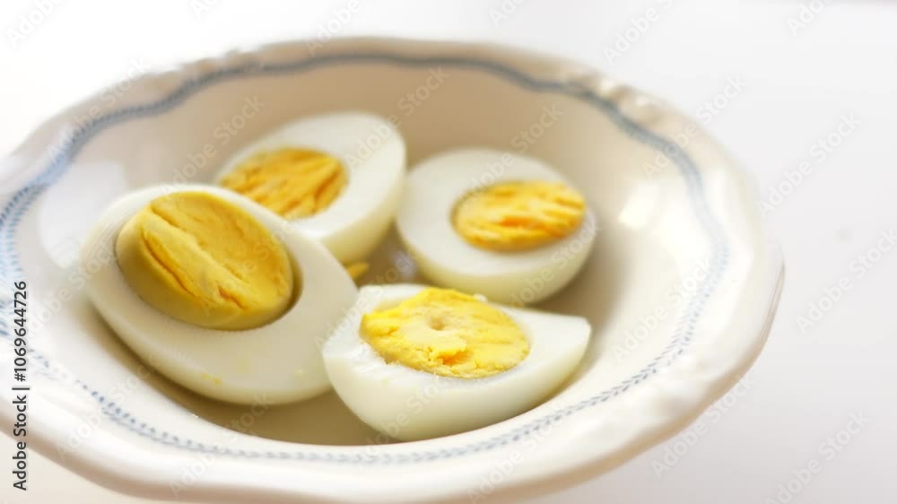 Enjoying deliciously sliced hardboiled eggs served in an elegantly crafted bowl Enjoying deliciously sliced hardboiled eggs served in an elegantly crafted bowl