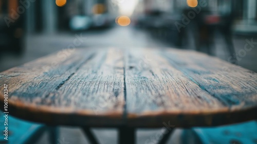 The rustic wooden table stands alone in an urban setting, surrounded by blurred city lights at dusk