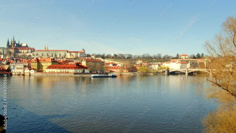 Scenic view of boats cruising on the Vltava River in Prague city in Czech Republic during daylight, with Prague’s iconic buildings and architecture in the background. Scenic view of boats cruising on the Vltava River in Prague city in Czech Republic during daylight, with Prague’s iconic buildings and architecture in the background.