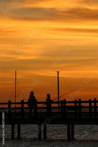 Obraz na płótnie Niño pescando junto a su madre en el atardecer en La Paz México w salonie