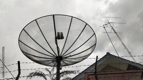 Foto Television mesh parabolic antenna on dark cloudy weather