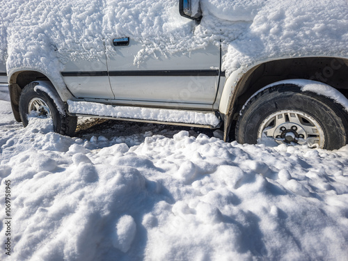 snow covered old white SUV car at sunny white winter day photo