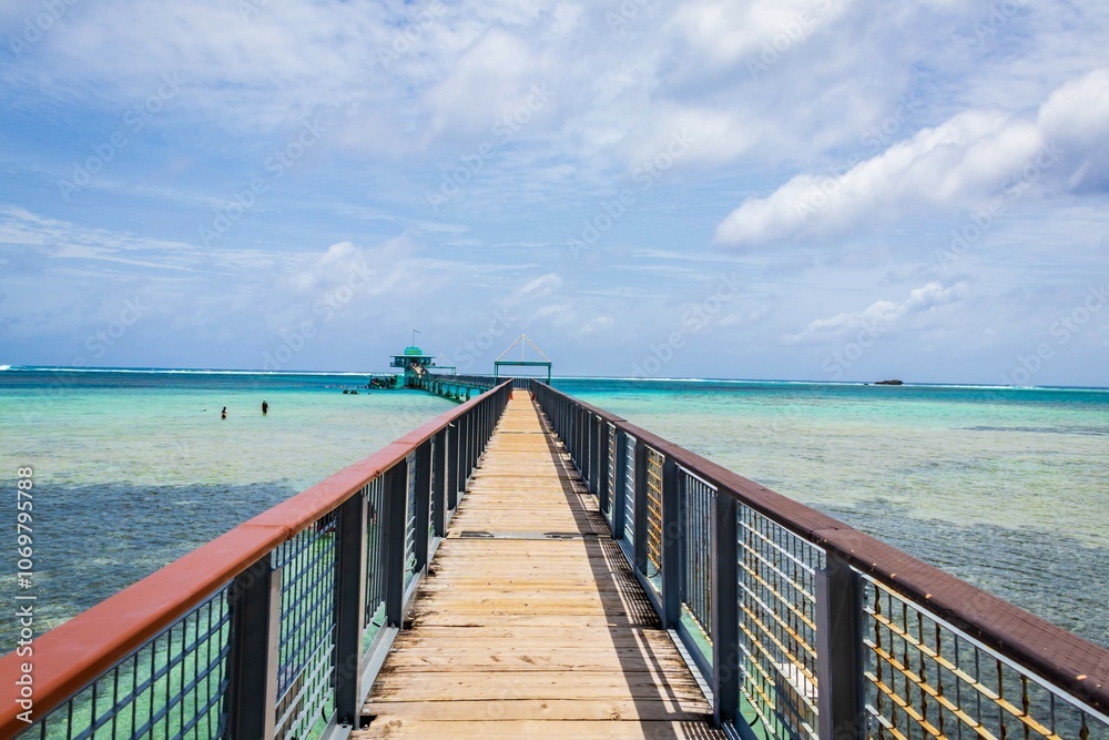 Scenic Wooden Pier Leading to Turquoise Waters and Horizon, Guam Scenic Wooden Pier Leading to Turquoise Waters and Horizon, Guam