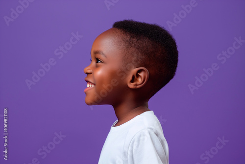 little boys' side profile on a bright purple studio background