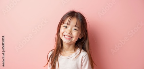 Happy young girl with long hair smiles in front of a pink background, perfect for family-oriented projects, childrens products, or educational materials.