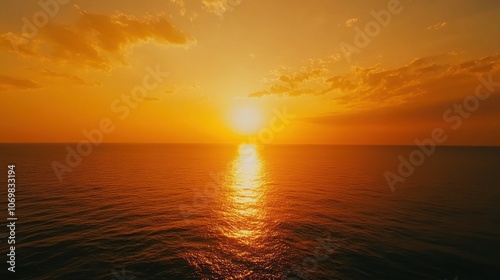 A serene sunset over the ocean, reflecting warm hues on the water's surface.